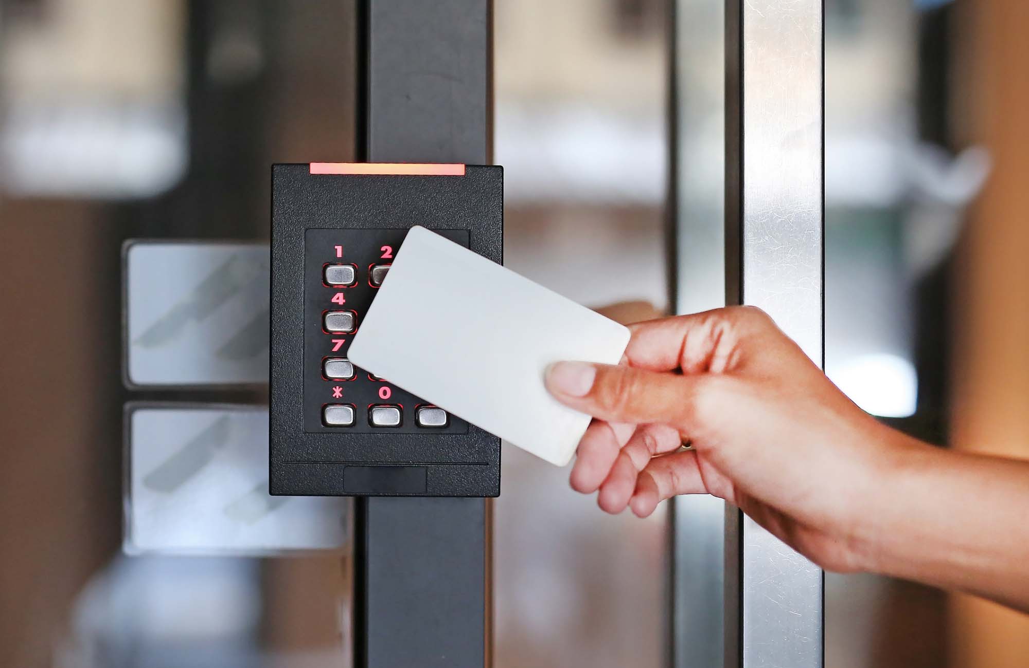 Door access control - young woman holding a key card to lock and unlock door.